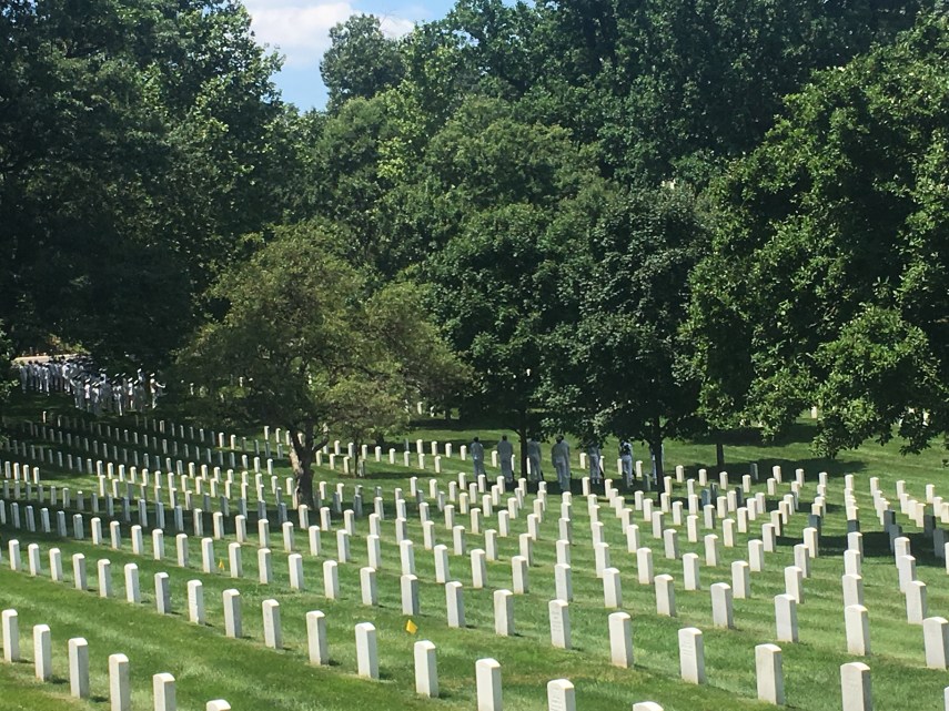 Arlington Cemetery graves and a group of Navy soldiers waiting for a funeral
